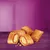 Image showing several filled, flaky baked treats with a golden-brown crust and visible filling, displayed on a purple surface.