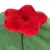 Giocattolo morbido a forma di fiore rosso su tessuto verde con superficie strutturata.