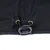 Close-up of black fabric with blue stitching, metal eyelets and an adjustable plastic drawstring.