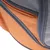 Détail d’une poche extérieure en tissu orange avec fermeture éclair grise et maille grise, partie d’un sac ou panier pour animaux.