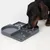 Chien mangeant dans un plateau d’alimentation en plastique gris à compartiments, avec restes de nourriture visibles dans plusieurs sections.