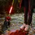 Luz LED roja brillante para correa de perro para mayor visibilidad en la oscuridad, fijada a correa amarilla. Perro y persona en acera otoñal con hojas.
