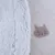 Gros plan sur deux tissus : à gauche, fausse fourrure blanche ; à droite, polaire beige avec motif tête de chat marron clair.