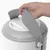 Hand lifts the grey handle of a white container with lid, showing the carrying function of the product.