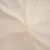 Gros plan sur un tissu beige avec couture centrale visible, matière textile lisse.