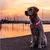 Collier lumineux pour chien, LED multicolores visibles autour du cou d’un chien assis en extérieur. Collier en plastique avec points lumineux roses et blancs.