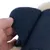 Gros plan sur une main soulevant une fermeture velcro noire d’un accessoire en tissu avec doublure intérieure beige visible.