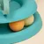 Jouet interactif en plastique bleu avec deux balles, une orange et une jaune, visibles dans un circuit circulaire.
