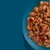 Close-up of wet food in gravy with pieces of meat and small vegetable chunks in a blue bowl. Close-up of wet food in gravy with pieces of meat and small vegetable chunks in a blue bowl.