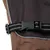 Close-up of a black snap fastener with reflective stripe on brown fabric.