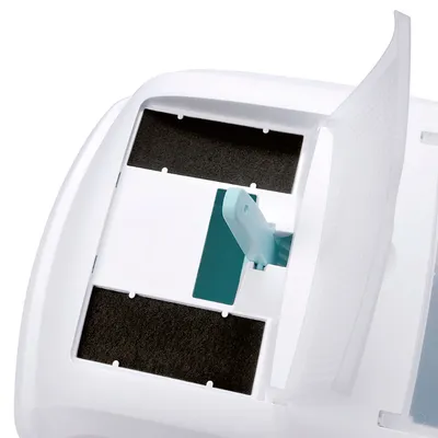 Couvercle blanc ouvert avec deux filtres noirs rectangulaires visibles et une poignée en plastique turquoise au centre, parties supérieures d’un bac ou d’une maison de toilette pour animaux.