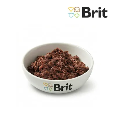 Miska z brązową mokrą karmą, na misce nadruk 'Brit' z symbolami. Logo Brit u góry na zdjęciu.