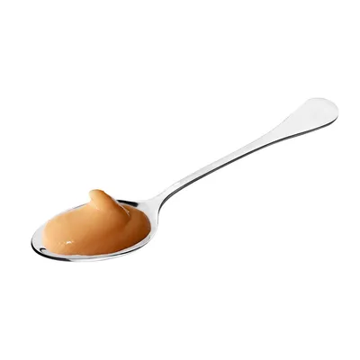 Silver spoon with a portion of brown paste, possibly food or supplement.