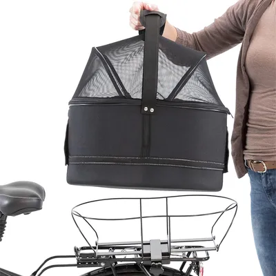 Schwarze Fahrradkorb-Tasche mit Netzabdeckung, wird von einer Person über einem Fahrradgepäckträger gehalten.