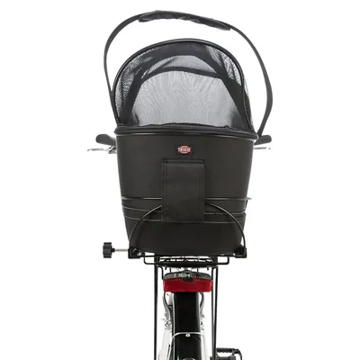 Cestino nero Trixie per bici con manico e copertura in rete, montato sul portapacchi posteriore di una bicicletta. Materiale tessuto visibile. Cestino nero Trixie per bici con manico e copertura in rete, montato sul portapacchi posteriore di una bicicletta. Materiale tessuto visibile.