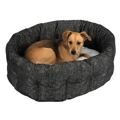 Letto per animali rotondo e imbottito in tessuto grigio scuro con superficie interna bianca.