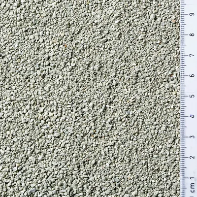 Närbild av grått granulat med centimeter-skala, visar kornstorlek och textur.