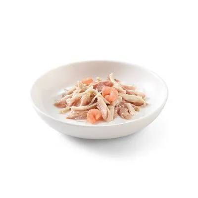 Wit keramisch schaaltje met natvoer bestaande uit stukjes vlees en enkele roze garnalen in gelei, zonder zichtbare merknaam of verpakking.