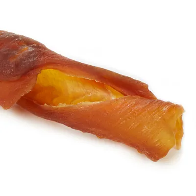 Primer plano de un snack masticable para perros retorcido de carne seca, color naranja-marrón con núcleo amarillo.