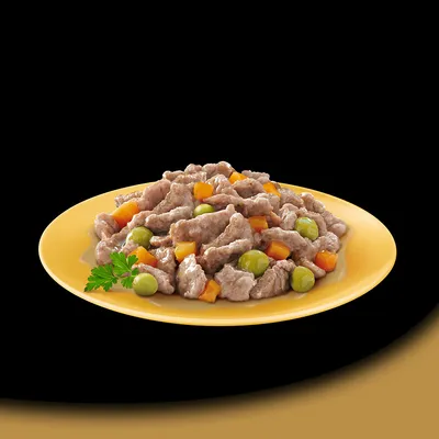 Chunks of meat with green peas and orange vegetable pieces served on a yellow plate, shown as a serving suggestion for pet food.