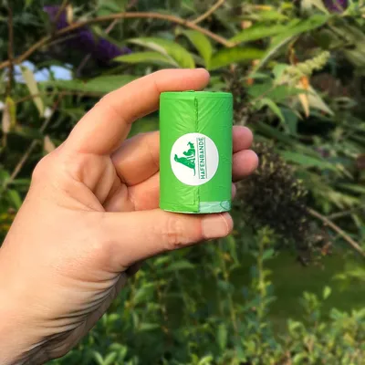 Rotolo di sacchetti verdi con etichetta HAFENBANDE tenuto in mano, materiale plastica visibile.