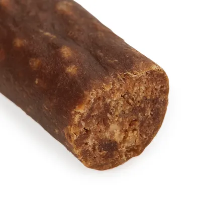 Posnetek od blizu rjave pasje poslastice z mehko, zrnato teksturo in ugriznjenim koncem.