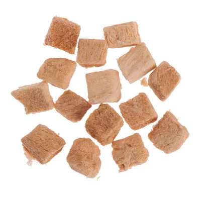 Morceaux cubiques de friandises pour animaux, couleur beige clair, texture fibreuse, disposés sur fond blanc. Aucun emballage ou texte visible.