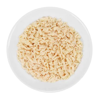 Wit bord met fijngesneden, lichtgekleurd vlees of vis, zonder zichtbare verpakking, merknaam of extra ingrediënten.