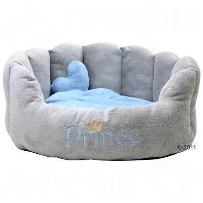 Panier pour animal en tissu gris avec coussin bleu et broderie « Prince » ornée d’une couronne dorée sur le devant. Forme ronde, bords rembourrés.