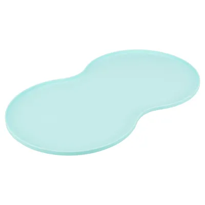 Light blue, kidney-shaped silicone mat for food bowls, non-slip and easy to clean.