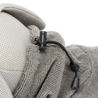 Gros plan sur un cordon de serrage noir avec stoppeur en plastique sur tissu gris à texture éponge et maille beige, matériaux visibles : tissu, plastique.