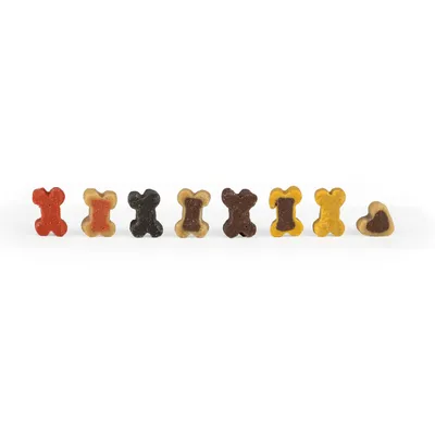 Bunte Hundeknochen-Leckerlis in verschiedenen Farben: Rot, Beige, Schwarz, Braun und Gelb. Kleine Knochenform sichtbar.