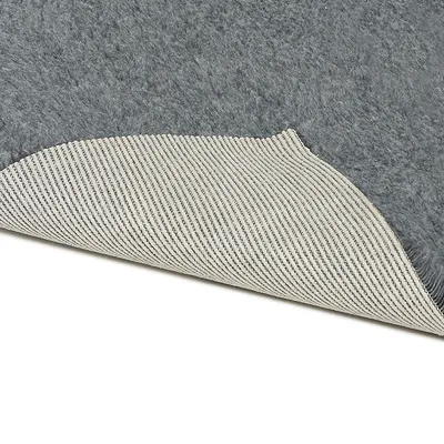 Grauer Teppich mit rutschfester Unterseite aus gestreiftem Material, geeignet für sicheren Halt auf glatten Böden.