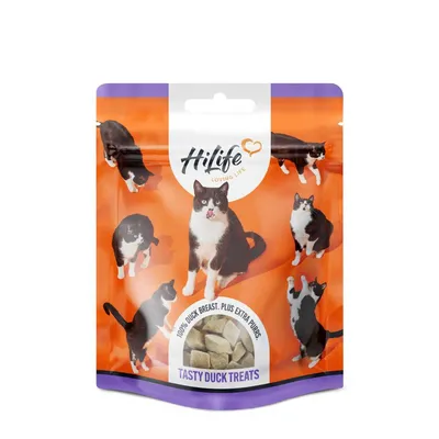 Pouch labelled 'Tasty Duck Treats' with visible text '100% duck breast. Plus extra purrs.' and images of black and white cats around a window showing cube-shaped treats.