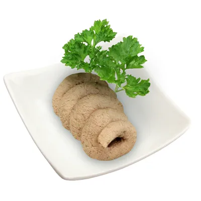 Tranches de pâtée beige disposées en éventail sur une assiette blanche carrée, garnies d'une branche de persil frais. Aucun emballage ou texte visible.