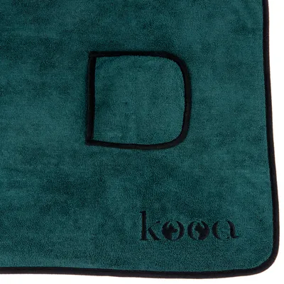 kooa. Dunkelgrüne Decke mit schwarzem Rand und aufgenähter Tasche, geeignet für Haustiere.
