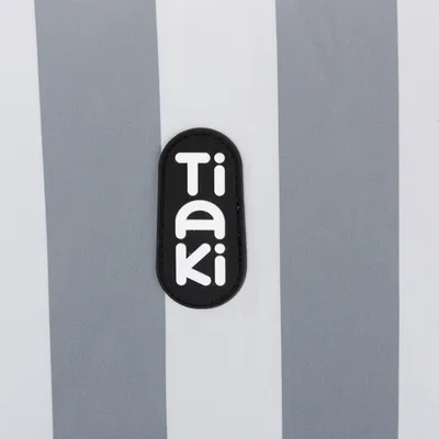 Tiaki-Logo auf grau-weiss gestreiftem Hintergrund.