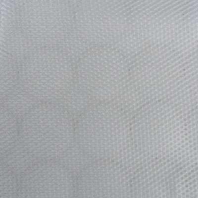 Zbliżenie białego materiału o strukturze plastra miodu z drobną fakturą.