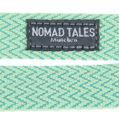Nomad Tales München. Тканый зеленый материал с зигзагообразным узором и фирменной этикеткой.