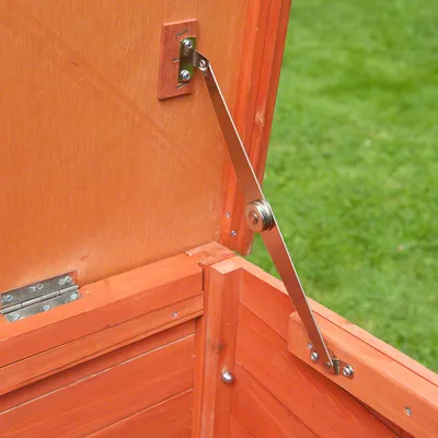 Metal support arm attached to the inside of a wooden lid, showing how the hinge mechanism holds the lid open securely.