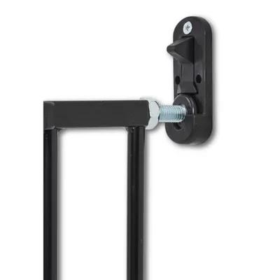 Detailní záběr na černý kovový rám se šroubovacím mechanismem a plastovým držákem na zeď.