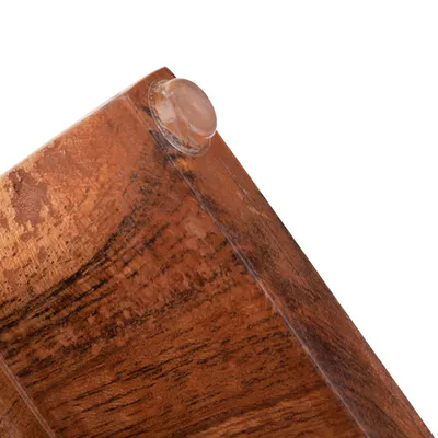 Nahaufnahme einer Holzoberfläche mit transparenter Gummifüsse zur Stabilisierung.