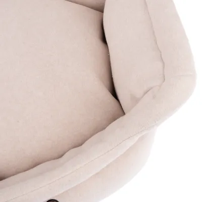 Close-up van een beige, gevoerd stoffen bed met zachte randen.