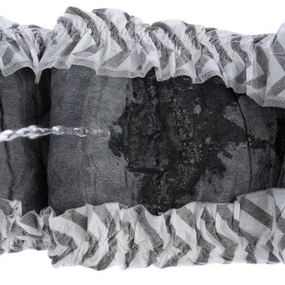 Close-up of a filter with a water jet flowing through activated carbon and filter layers. Shows the filter’s function for liquid purification.