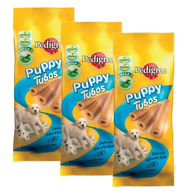 Three packs of Pedigree Puppy Tubos with chicken, highlighting vitamin, calcium and omega 3 content. Text states 'Delicious & Kind to Teeth' and 'x3'.