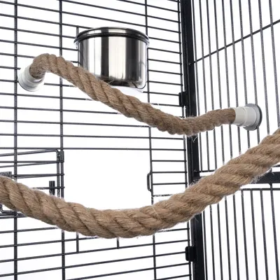 Cage with metal grid, stainless steel bowl and two attached ropes made of natural material.
