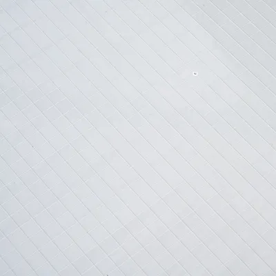 Weisse Oberfläche mit quadratischem Muster, geeignet für Produktpräsentationen oder Materialbeschreibung.