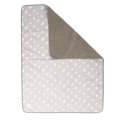 Couverture rectangulaire bicolore, une face grise à motifs silhouettes d’animaux blancs, l’autre face en tissu polaire marron. Matières visibles : tissu et polaire.