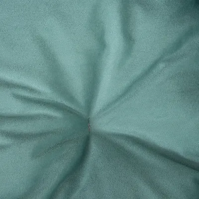 Close-up van een groene stof met fijne weefstructuur en een centrale plooi.
