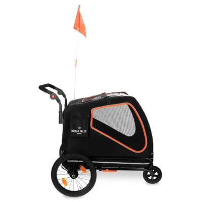 Nomad Tales cykelvagn med svart och orange design, nätfönster och säkerhetsflagga. Lämplig för transport av husdjur.